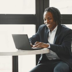Empreendedor trabalhando sozinho com laptop em escritório moderno, representando o modelo de negócio solo com IA