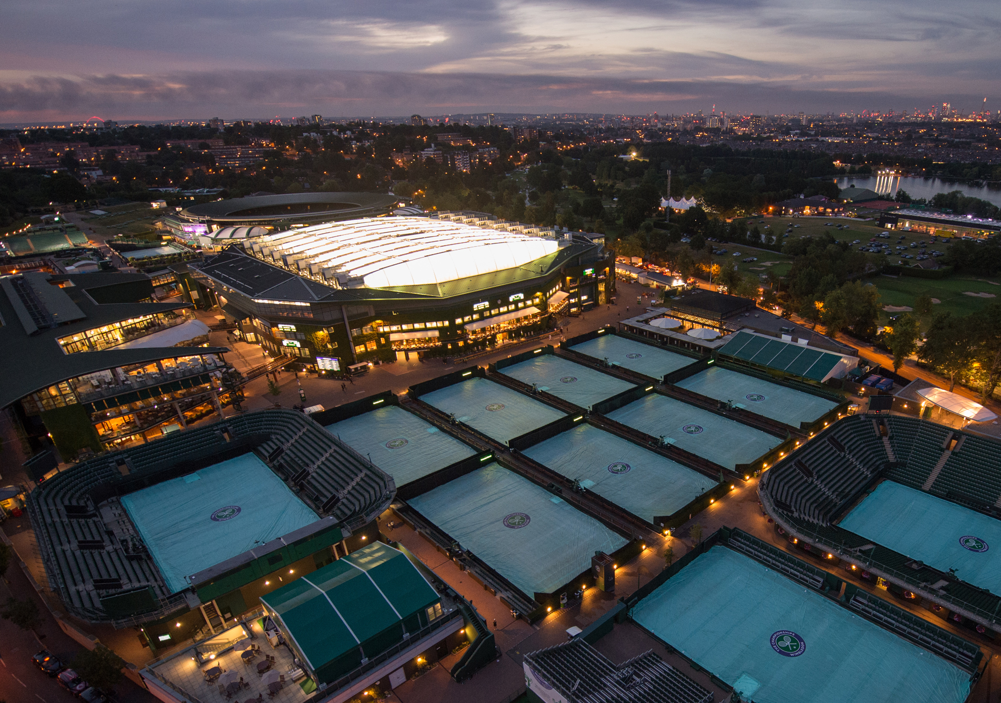 Vista aérea noturna de Wimbledon com a Centre Court iluminada
