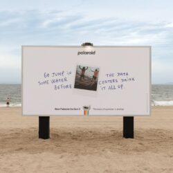 Outdoor da Polaroid na praia de Coney Island com mensagem analógica contra os data centers de IA